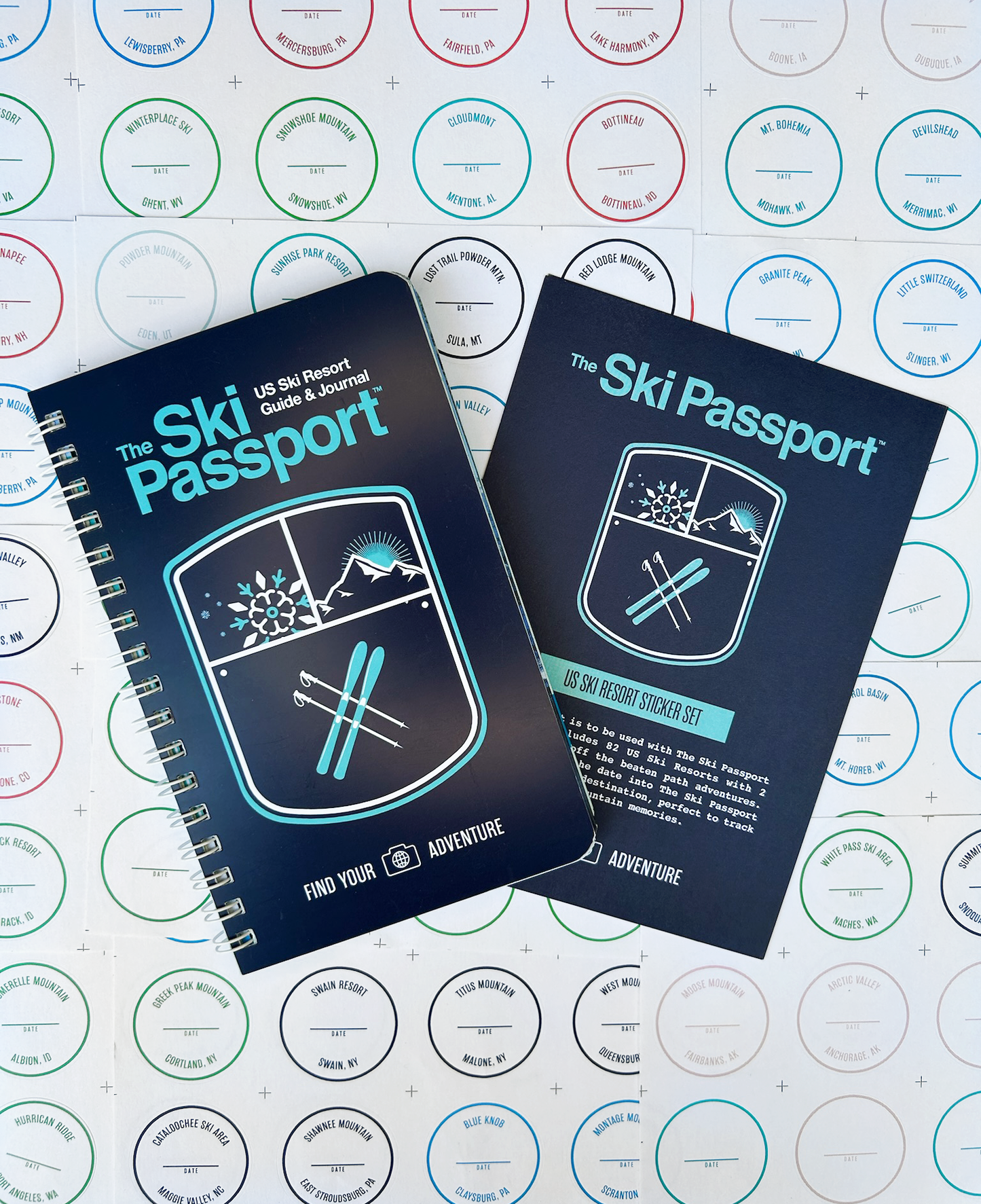 The Ski Passport journal and the resort sticker set with ski resort stickers in the background