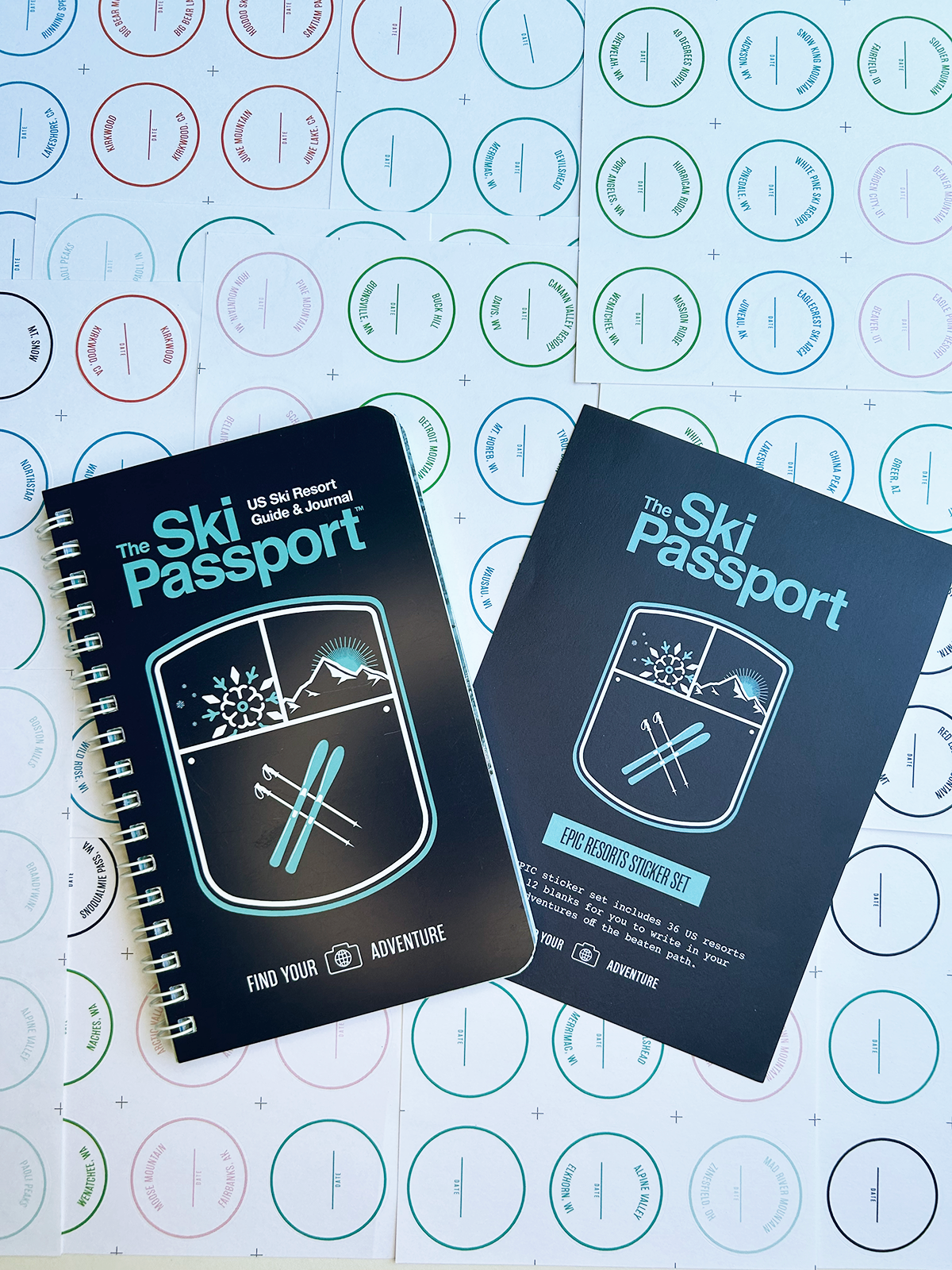 The Ski Passport journal and the epic resort sticker set with ski resort stickers in the background