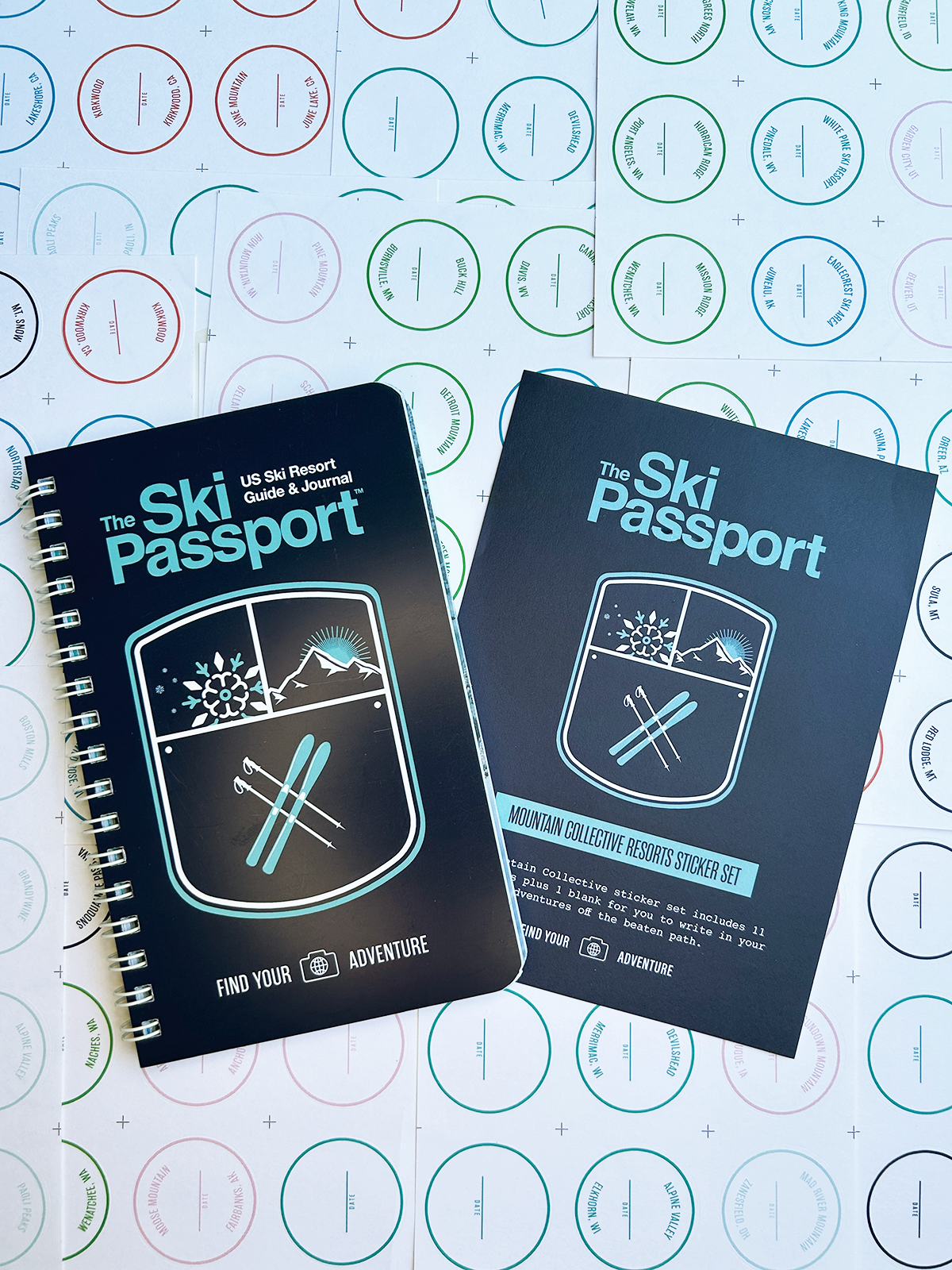 The Ski Passport journal and the mountain resort sticker set with ski resort stickers in the background